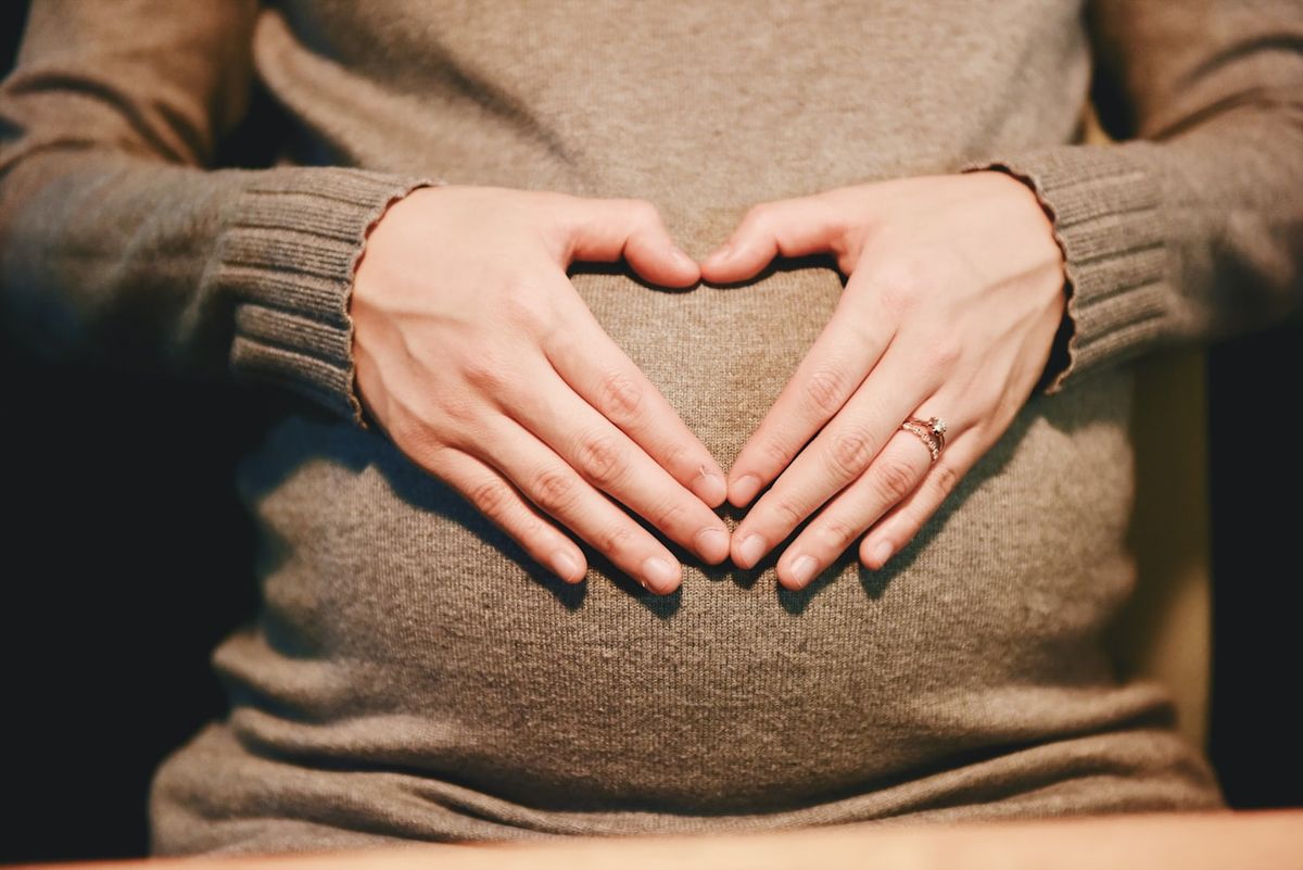 Gravid kvinne holder rundt magen