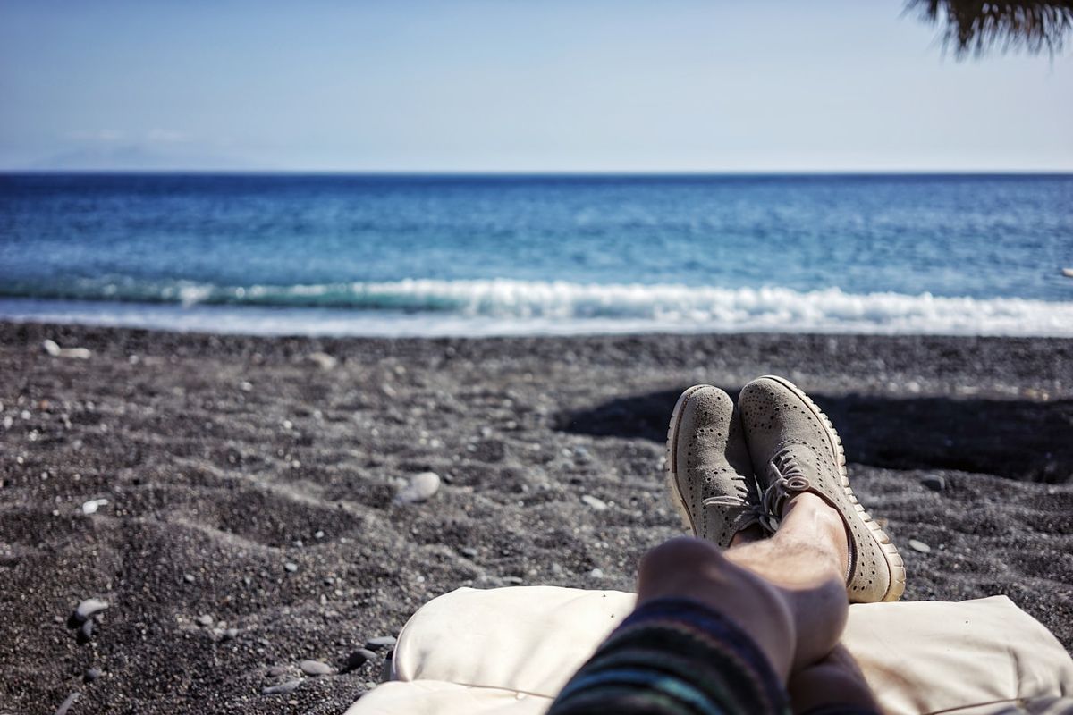 Person som slapper av på stranden med utsikt mot havet
